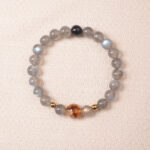Moonstone bracelet with gentle blue sheen and golden accent bead, symbolizing calmness and intuition.