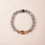 Moonstone bracelet with gentle blue sheen and golden accent bead, symbolizing calmness and intuition.