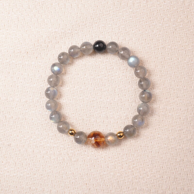 Moonstone bracelet with gentle blue sheen and golden accent bead, symbolizing calmness and intuition.