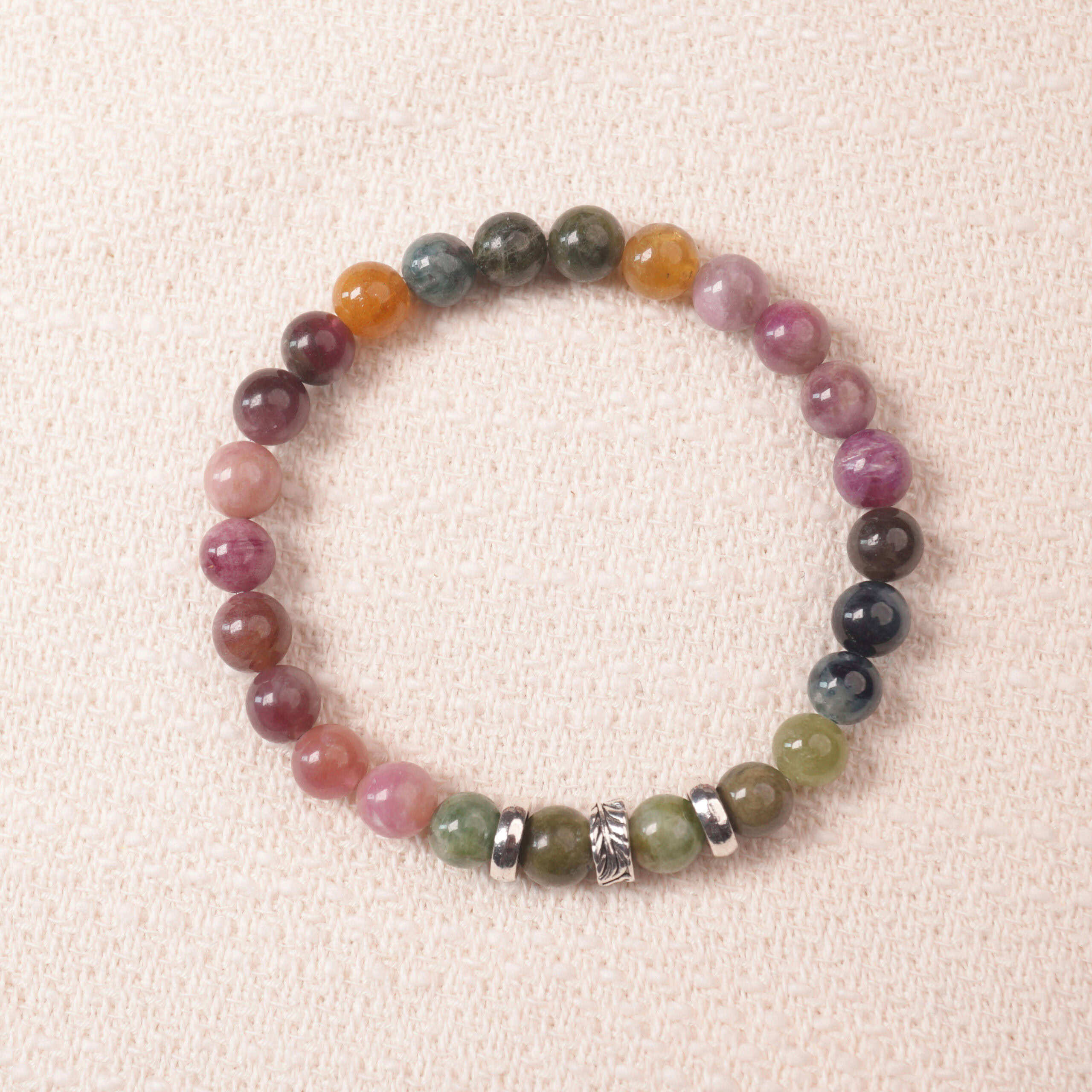 multicolor-tourmaline-bracelet-natural-light Multicolor tourmaline bracelet photographed under soft daylight on a neutral background, showing the natural gradient of pink, green, and brown gemstones.