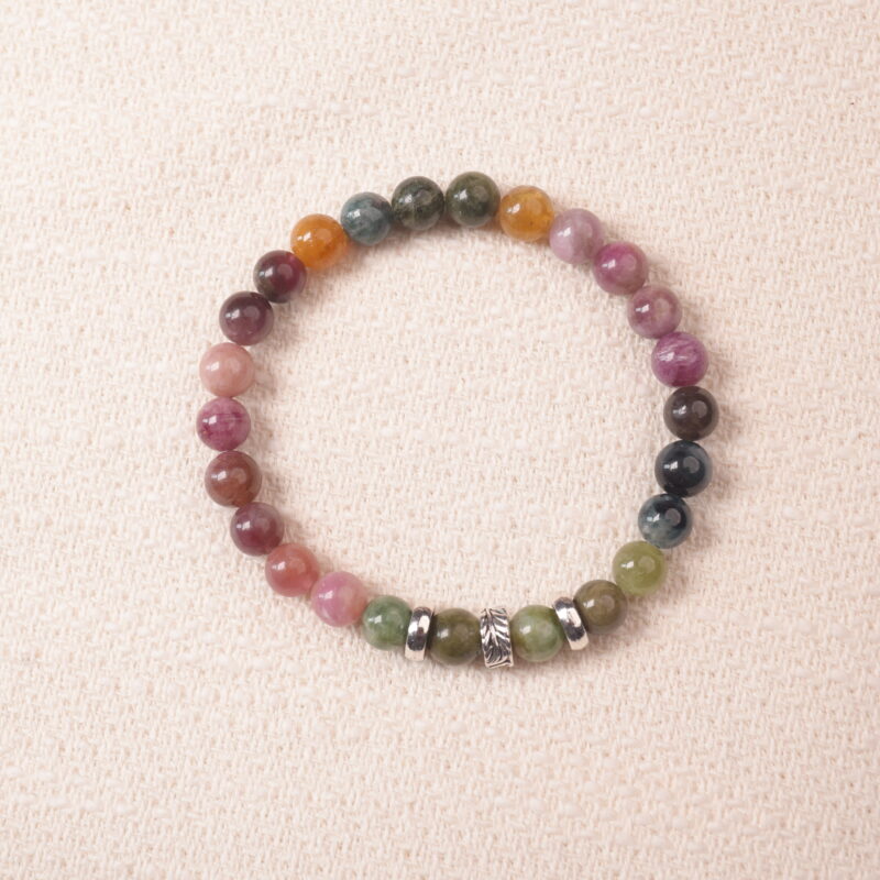 Multicolor tourmaline bracelet photographed under soft daylight on a neutral background, showing the natural gradient of pink, green, and brown gemstones.