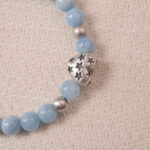Detailed view of aquamarine beads showing translucent sky-blue color and smooth polish.
