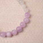 Close-up of kunzite and moonstone beads showing translucent pastel color and smooth polish.