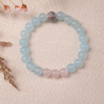 Lifestyle photo of aquamarine and rose quartz bracelet placed beside dried flowers, radiating calm energy.