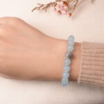 Model wearing aquamarine and rose quartz bracelet, showing soft blue tone and romantic elegance.