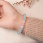 Back view of aquamarine and rose quartz bracelet highlighting pastel hues and smooth round stones.