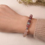 Model wearing strawberry quartz and amethyst bracelet, showcasing warm pink hues and elegant shine.