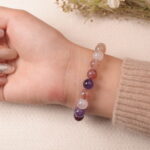 Back view of strawberry quartz bracelet featuring polished gemstones in pink and violet tones.