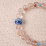 Close-up of Red Hematoid Quartz bracelet showing natural red mineral inclusions and glossy texture.