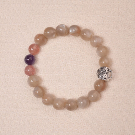 Moonstone, Amethyst, and Strawberry Quartz bracelet with a silver flower accent bead, designed for tranquility and emotional healing.