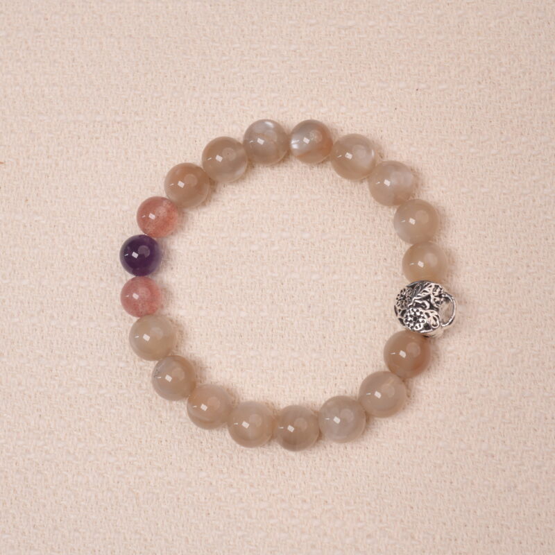 Moonstone, Amethyst, and Strawberry Quartz bracelet with a silver flower accent bead, designed for tranquility and emotional healing.
