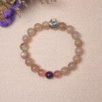 Lifestyle image of Moonstone, Amethyst, and Strawberry Quartz bracelet, placed elegantly among delicate accessories.