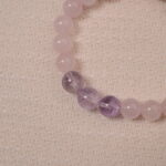 Close-up of Tranquil Love bracelet, showcasing the polished Rose Quartz and Amethyst beads with a sparkling Heart Silver charm.