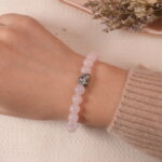 Model wearing Tranquil Love bracelet, showcasing the beautiful combination of soft pink and purple beads with a heart-shaped silver charm.