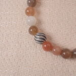 Close-up of the multicolor Moonstone beads, showing their smooth texture and unique hues, with a silver accent bead adding a sophisticated touch.