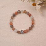 The multicolor Moonstone bracelet laid on a soft fabric background, highlighting its pastel colors and elegant design, perfect for a serene and tranquil atmosphere.