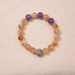 Citrine and amethyst bracelet featuring natural golden and purple beads, symbolizing wealth and wisdom.