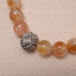 Close-up of citrine and amethyst bracelet showing polished crystal texture and color contrast.