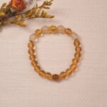 The Citrine bracelet laid on a soft fabric background, the golden beads reflecting light beautifully, creating a warm and radiant glow. Perfect for adding a touch of luxury to any outfit.