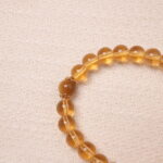Close-up detail of the Citrine bracelet, highlighting the smooth texture of the golden Citrine beads and the central golden accent bead, showcasing the bracelet’s fine craftsmanship.