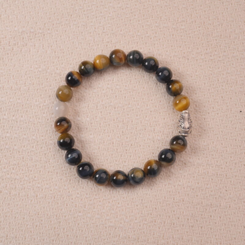 A close-up of a Tiger Eye and Moonstone bracelet, featuring glossy Tiger Eye beads and smooth Moonstone beads. The bracelet is adorned with a silver spacer bead, adding an elegant touch to the combination of rich brown and milky white gemstones.