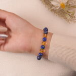 A hand wearing the Lapis Lazuli and Citrine bracelet. The combination of deep blue and vibrant yellow gemstones creates an eye-catching and energizing accessory.