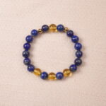 A close-up of a Lapis Lazuli and Citrine bracelet, featuring polished deep blue Lapis Lazuli beads and bright yellow Citrine beads. The bracelet is accented with gold spacer beads for a luxurious touch.