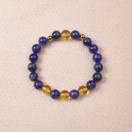 A close-up of a Lapis Lazuli and Citrine bracelet, featuring polished deep blue Lapis Lazuli beads and bright yellow Citrine beads. The bracelet is accented with gold spacer beads for a luxurious touch.