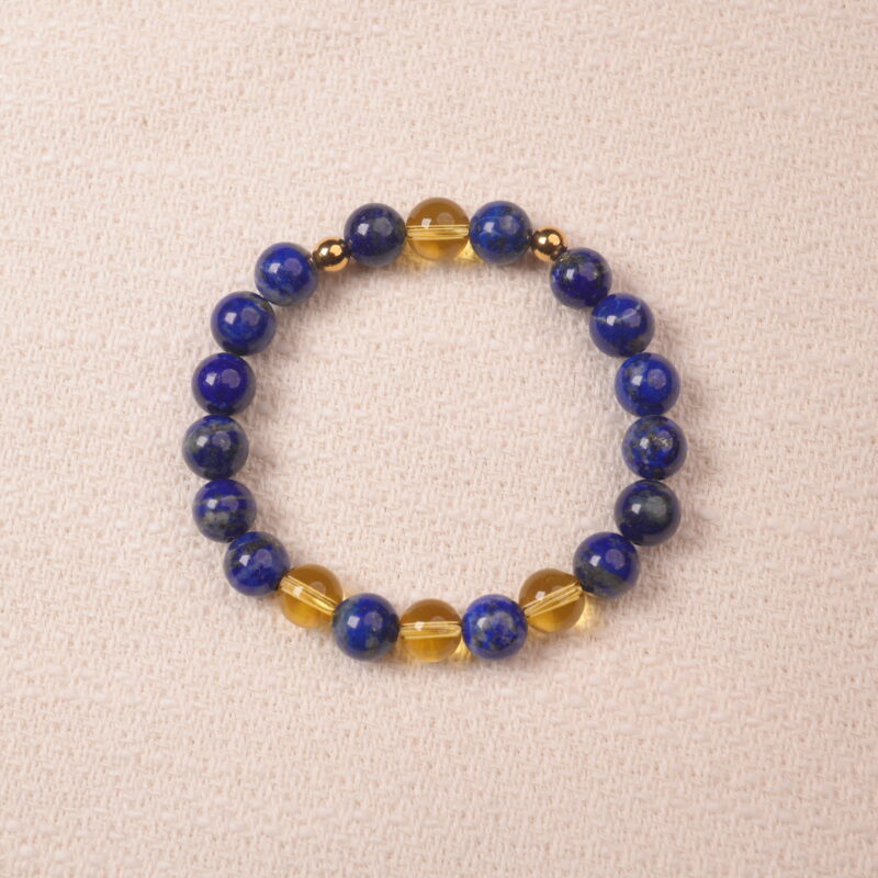 A close-up of a Lapis Lazuli and Citrine bracelet, featuring polished deep blue Lapis Lazuli beads and bright yellow Citrine beads. The bracelet is accented with gold spacer beads for a luxurious touch.
