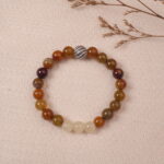 The Yellow Chalcedony and White Chalcedony bracelet placed on a soft fabric background, surrounded by delicate natural elements. The contrast between the warm and cool tones of the gemstones creates a balanced and calming aesthetic.