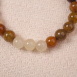 A detailed close-up of the Yellow Chalcedony and White Chalcedony bracelet, showing the polished surface of the beads and the S925 silver spacer bead. The natural variations in color enhance the unique beauty of the bracelet.