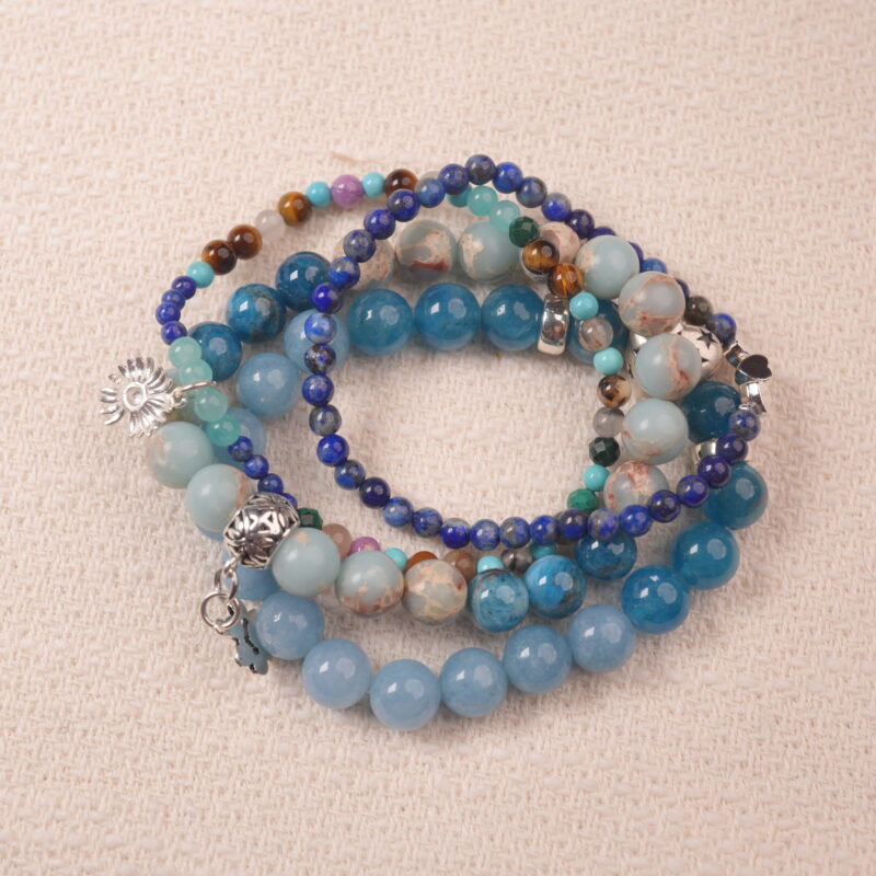 Communication intention bracelet stack with ocean-blue gemstones, symbolizing clarity, calm, and confident expression.