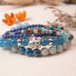 Silver charm detail from the Ocean Whisper bracelet, representing voice, clarity, and peaceful communication.