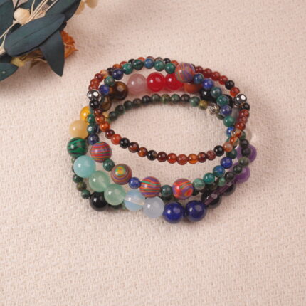 Multi-gemstone bracelet stack for good luck, featuring colorful natural crystals arranged in vibrant layers.