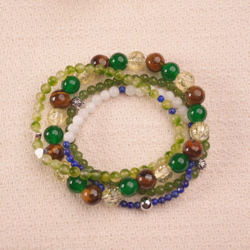 Good luck intention bracelet stack with green and golden gemstones, symbolizing growth, positivity, and fortune.