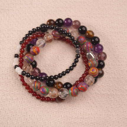 Vitality intention bracelet stack with red, brown, and purple gemstones, symbolizing strength, passion, and confidence.