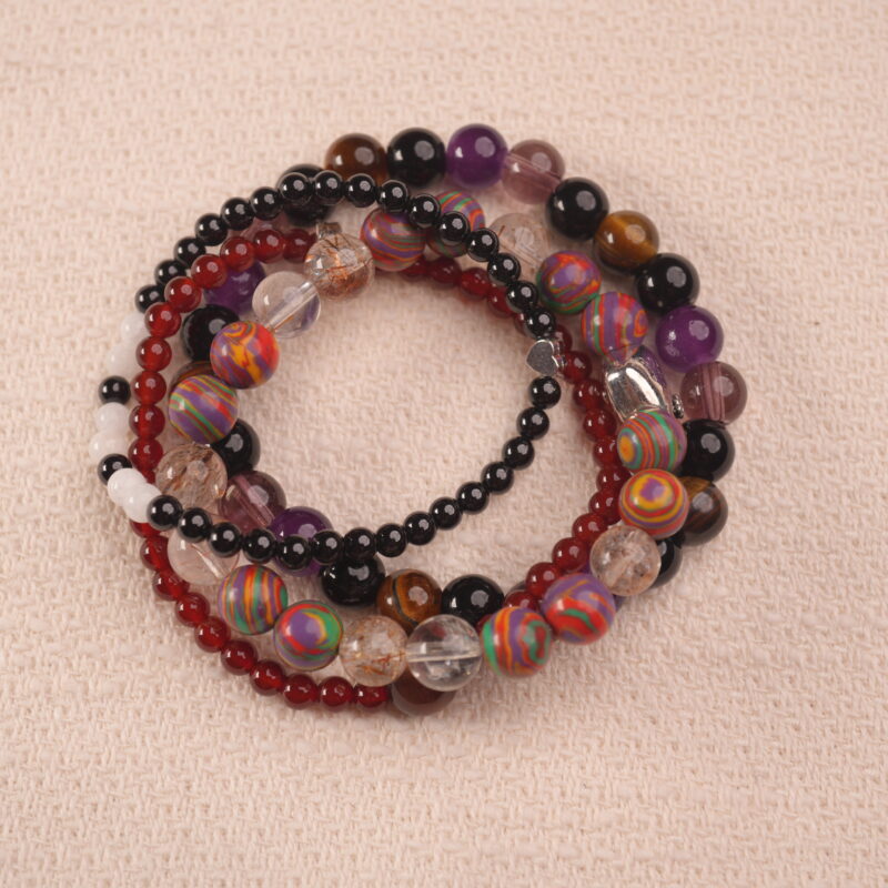 Vitality intention bracelet stack with red, brown, and purple gemstones, symbolizing strength, passion, and confidence.