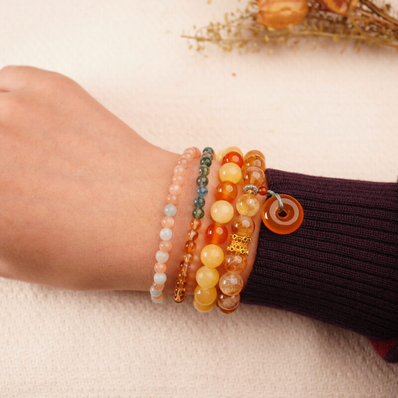 Model wearing the Golden Glow wealth bracelet stack — a daily charm for abundance and good fortune.1