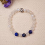 The Moonstone and Lapis Lazuli bracelet laid beside flowers, highlighting its elegant design and the harmonious balance of calming moonstone and bold lapis lazuli.