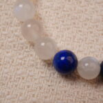A close-up of the Lapis Lazuli and Moonstone bracelet, highlighting the smooth, cool texture of the Moonstone beads and the deep blue of the Lapis Lazuli, separated by elegant silver spacers.