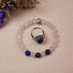 The Lapis Lazuli and Moonstone bracelet, paired with the Lapis Lazuli ring, placed beside delicate flowers. The vibrant blue stones and calming hues create a serene and harmonious atmosphere.