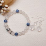 The Moonstone and Kyanite bracelet and Clear Quartz earrings displayed together on a soft fabric background, highlighting their calming hues and elegant design.