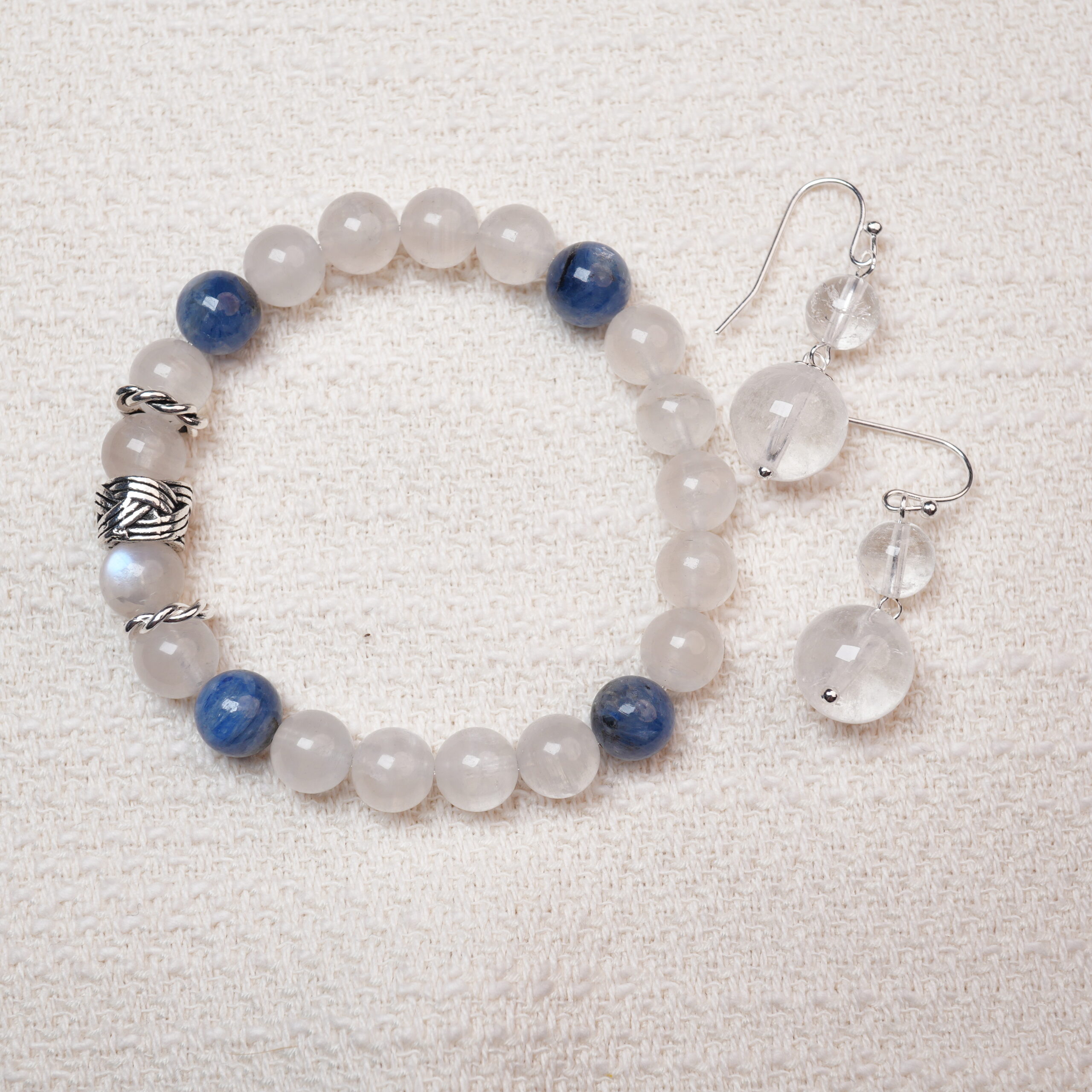 moonstone-kyanite-bracelet-crystal-earrings-set-main A beautiful set featuring a Moonstone and Kyanite bracelet paired with matching Clear Quartz earrings, designed to bring harmony and tranquility with their elegant energy.