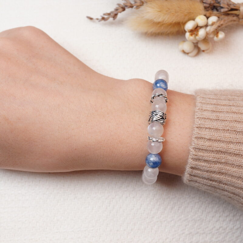 A model wearing the calming Sodalite and Moonstone bracelet on their wrist, featuring soothing blue Sodalite beads interspersed with transparent Moonstone beads and elegant silver accents. The combination of these stones is known for promoting peace, balance, and calm energy.