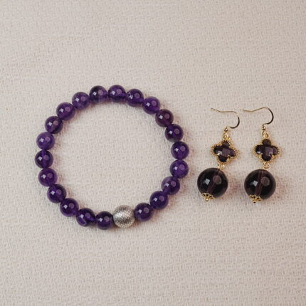 A stunning set featuring a vibrant Amethyst bracelet paired with matching Amethyst earrings. The bracelet is adorned with a silver accent bead, while the earrings showcase elegant Amethyst stones. Together, they create a sophisticated and calming accessory combination.