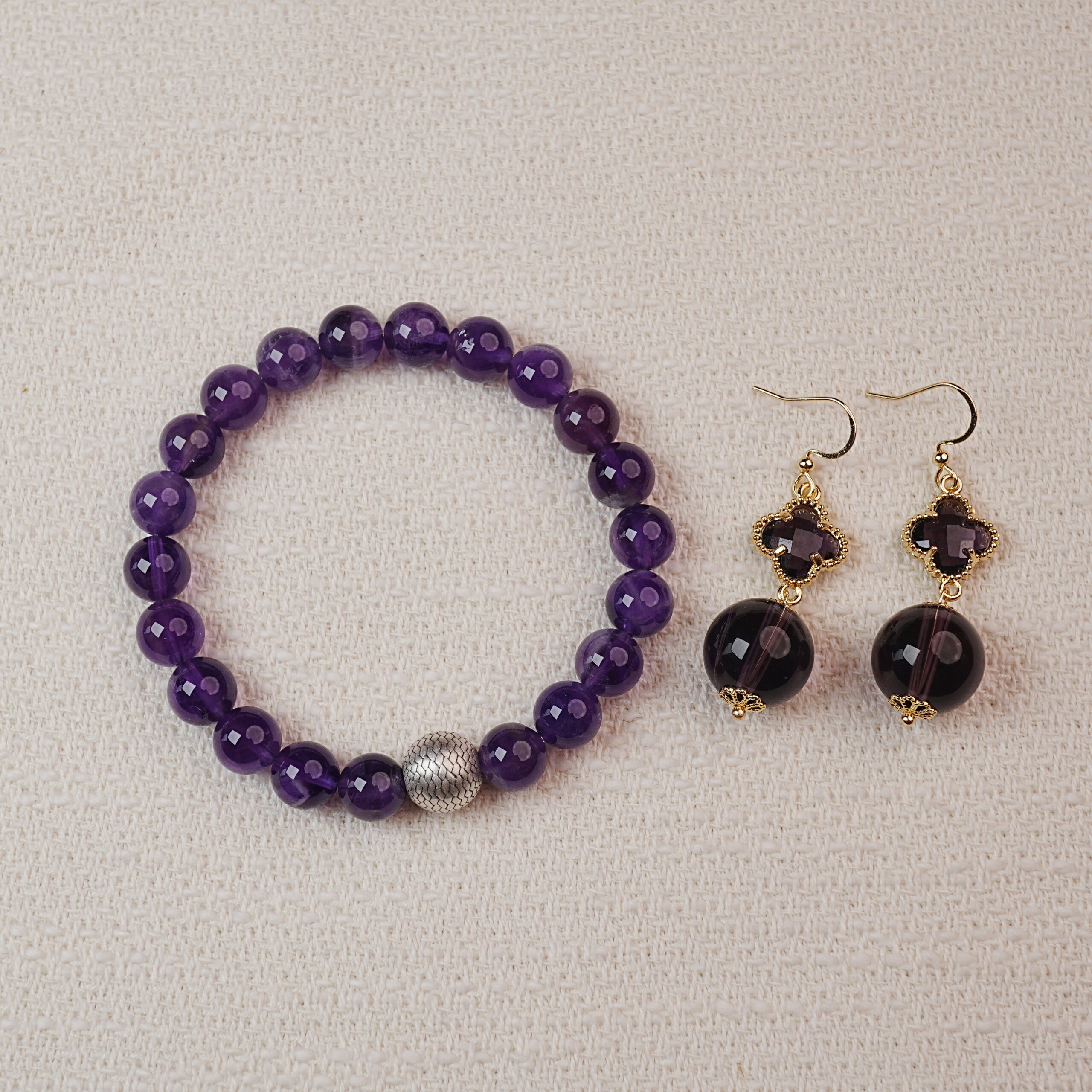 amethyst-bracelet-earring-set-main A stunning set featuring a vibrant Amethyst bracelet paired with matching Amethyst earrings. The bracelet is adorned with a silver accent bead, while the earrings showcase elegant Amethyst stones. Together, they create a sophisticated and calming accessory combination.