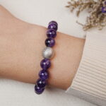 Amethyst bracelet with a silver bead worn on the wrist, showing the front view of the bracelet.