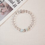 Clear Quartz beaded bracelet styled in a soft flat-lay scene.