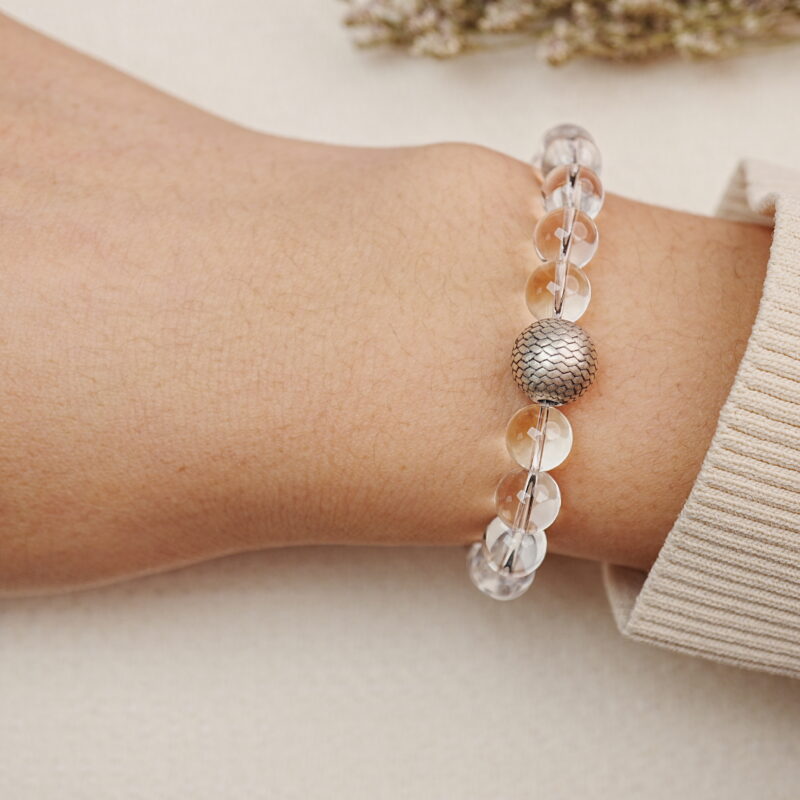 Clear Quartz bracelet worn on wrist with a silver accent bead.