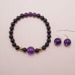 A striking set featuring a Black Obsidian Amethyst Bracelet with a gold accent bead and matching Amethyst Ball Earrings. Elegant and bold, this set enhances any outfit with its deep amethyst hues and contrasting black and gold accents.